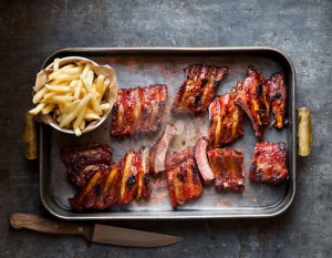 Grilled ribs sliced with a bowl of fries chips